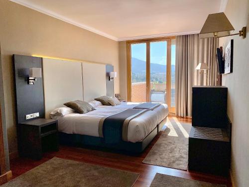 巴绍里阿尔米内酒店的一间卧室设有一张大床和一个大窗户