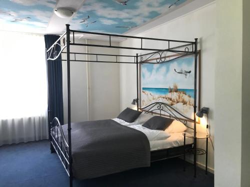 雷讷瑟Fletcher Strandhotel Renesse的一间卧室配有一张带海洋绘画的天蓬床