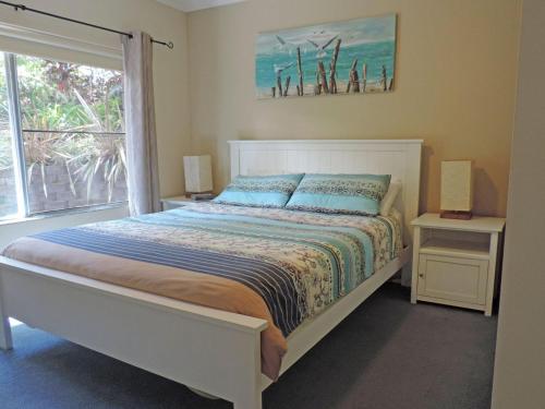 浅滩湾Adriana 3 unit with a backyard的一间卧室设有一张床和一个大窗户