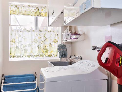 浅滩湾Adriana 3 unit with a backyard的厨房配有洗衣机和窗户。
