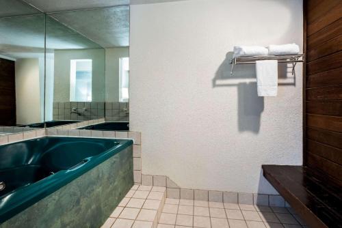 本德拉金塔本德旅馆的一间带大浴缸和镜子的浴室