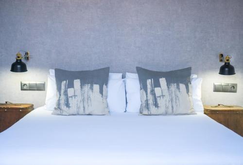 马拉加灯光旅舍 的卧室内的一张带白色床单和枕头的床