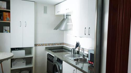 休达Beatiful and full-equipped flat in the city center的白色的厨房设有水槽和炉灶。