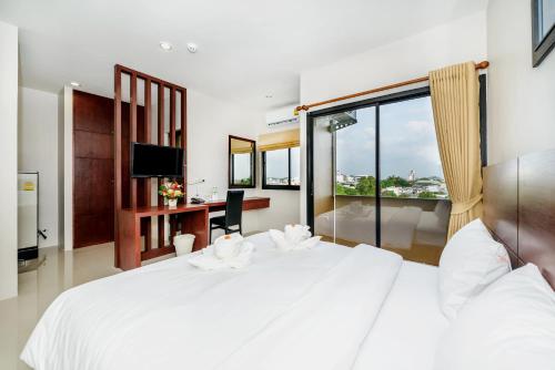 普吉镇The Topaz Residence Phuket Town的卧室设有一张白色大床和一扇窗户。