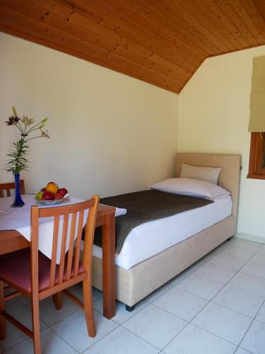 塞里特雷尼科科拉纳简易别墅酒店 - 科拉纳营地的一间卧室配有一张床和一张桌子及一碗水果