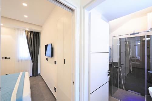阿马尔菲Amalfi Blu Retreat的一间卧室设有滑动玻璃门,可通往淋浴