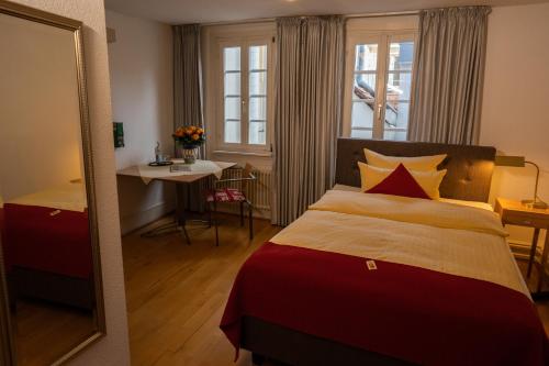 海德堡金福克酒店的一间卧室配有一张床、一张桌子和一面镜子