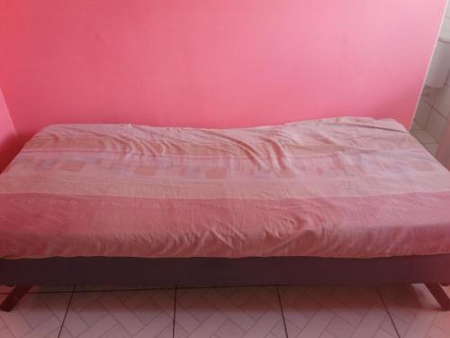 特雷西纳CASA das ORQUÍDEAS NOTA 1000的粉红色墙壁的房间里一张床位