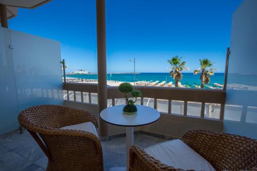 罗希姆诺西奥海滩酒店式公寓的一个带桌椅和海滩的阳台
