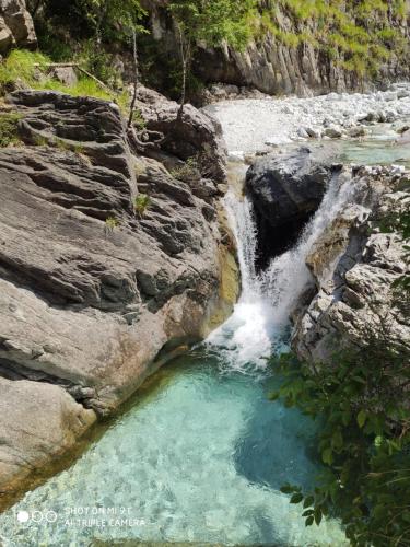 马萨Incantevole casa sul fiume, Relax e Natura ai piedi della Alpi Apuane的河中的瀑布,有水池