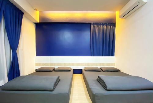 马六甲Amadel Residence 爱媄德民宿 13的配有蓝色窗帘的客房内的两张床