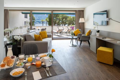 洛迦诺Hotel Lago Maggiore - Welcome!的客厅配有沙发和餐桌,