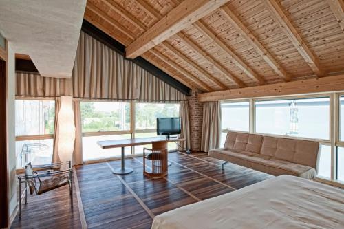 多索博诺韦罗内西拉托雷酒店的一间卧室配有一张床、一张沙发和一张桌子