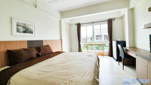 梭桃邑Neo km10โรงแรมที่พักใกล้สนามบินอู่ตะเภา แสมสาร สัตหีบ บ้านฉาง的一间卧室配有一张床、一张书桌和一个窗户。