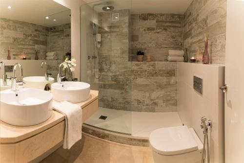 锡切斯地中海锡切斯度假酒店的一间带两个盥洗盆和淋浴的浴室