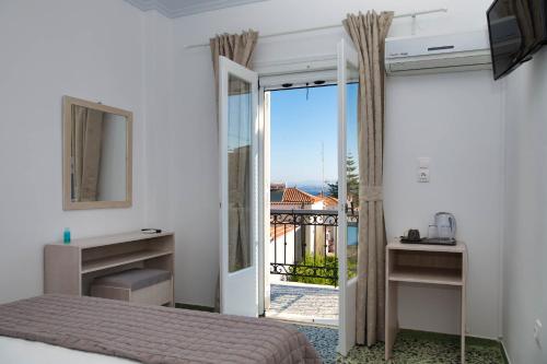 斯派赛斯Argonaftis Spetses的一间卧室设有一张床,并有通往阳台的门