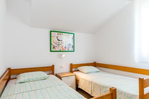 希贝尼克Jadrija Bay的卧室配有两张床,墙上挂着一幅画