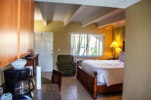 圣徒皮特海滩湾畔及滨海旅馆的一间卧室配有一张床、一把椅子和一张桌子