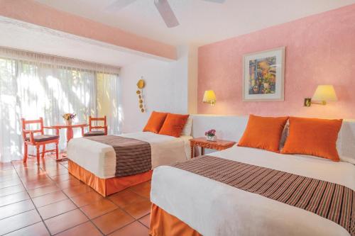库埃纳瓦卡库埃纳瓦卡瑞凯特酒店 - 欧斯达的酒店客房设有两张床和一张桌子。