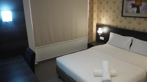 马六甲906 Hotel Kota Laksamana的一间卧室配有一张带两张蜡烛的床。