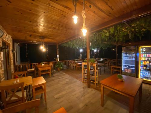法拉尔雅Faralya Misafir Evi的餐厅设有木制天花板和桌椅