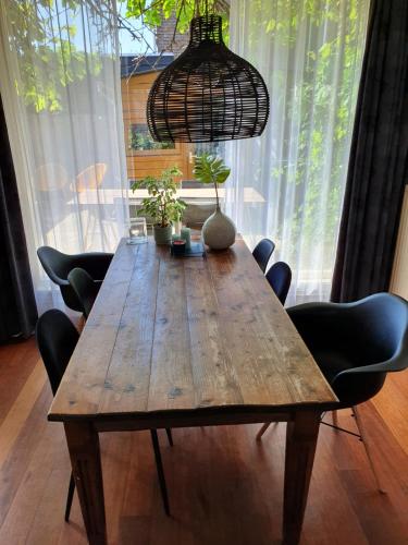 鹿特丹Single family home in Hillegersberg - Schiebroek的一张带椅子的木桌和吊灯