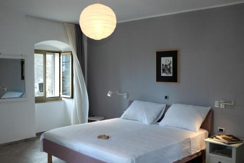 佩罗杰Moderno 3 Casa Vecchia的卧室配有白色大床和灯