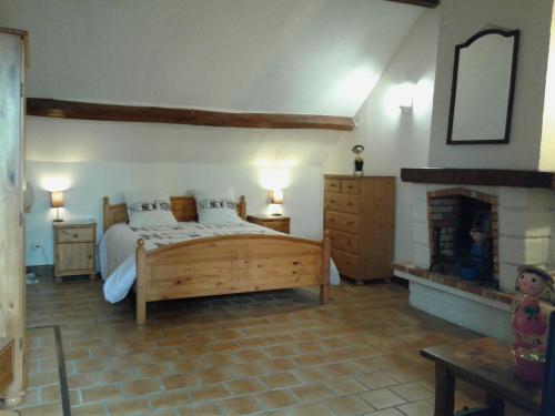 HénonvilleAu Grand Sapin Chambres chez l'habitant的一间卧室设有一张大床和一个壁炉