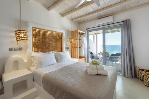 德里奥斯Blue Waves Suites & Apartments - To Kyma的一间卧室设有一张床,享有海景