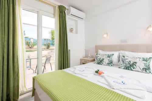斯卡拉伯塔麦斯Stratos Deluxe Apartments的一间卧室配有一张带绿色窗帘的床和窗户。