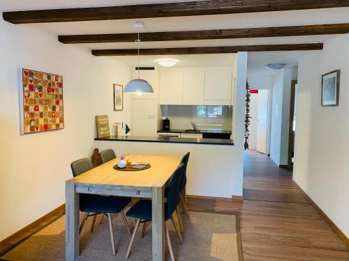 采尔马特伊兰公寓度假屋的厨房以及带木桌和椅子的用餐室。