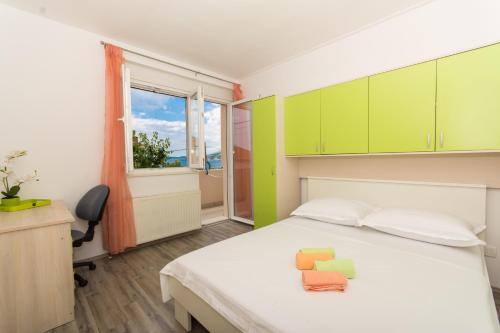 特罗吉尔Apartments Ploka的一间卧室配有一张带绿色橱柜的床和窗户。