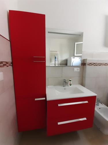 波代诺内CASA CONTE的一间带红色橱柜和水槽的浴室