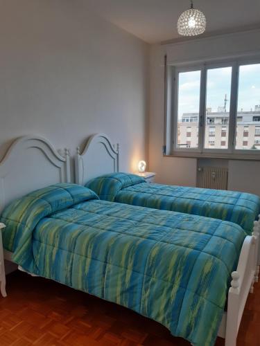 波代诺内CASA CONTE的卧室内的两张床,配有蓝色和黄色的床单