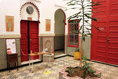 拉巴特梅塔哈摩洛哥传统庭院住宅旅馆的一间红色门的房间和盆栽