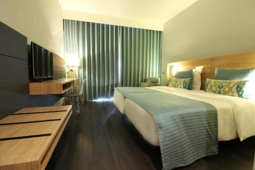 丰沙尔马德拉美景酒店的酒店客房设有一张大床和一台电视。