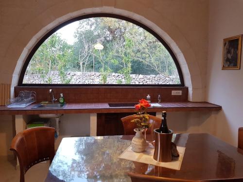 奥斯图尼特鲁利奥拉西亚度假屋的厨房配有桌子和大窗户