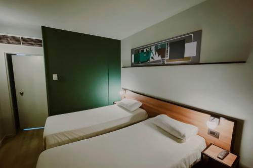 门多萨门多萨宜必思酒店的两张床铺,位于酒店客房,墙上配有电视