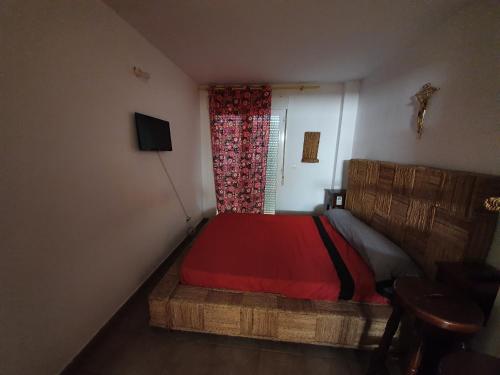 阿尔么丽亚Habitaciones en Casa compartida Retamar的一间卧室配有一张带红色棉被的床和窗户。