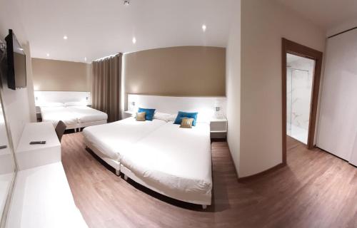 米尼奥Hotel La Terraza的一间卧室配有两张带蓝色枕头的床