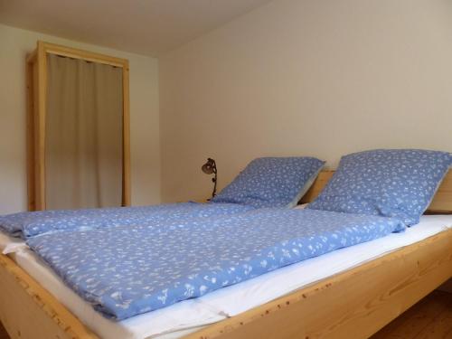HinterweilerHaus Schritte的床上铺有蓝色枕头的床