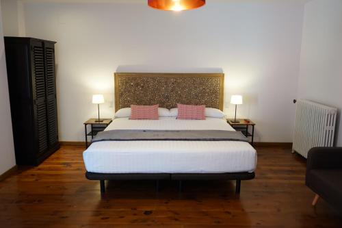 贝尔维尔德赛当亚Fonda Biayna的卧室配有一张大床和两个粉红色枕头