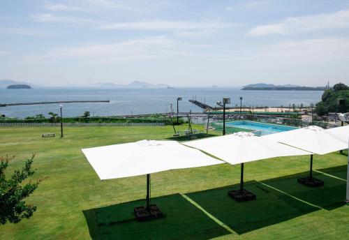 仓敷仓敷海滨酒店的一个带白色遮阳伞和水的游泳池