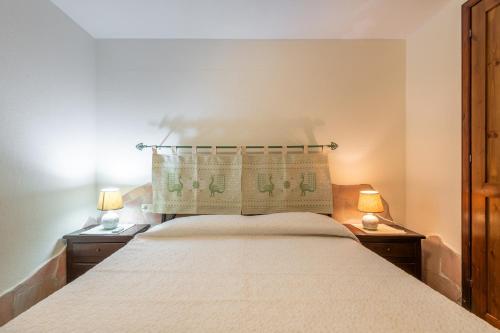 西缪斯Villetta Passudedantza的一间卧室配有一张大床和两盏灯