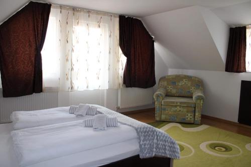 索瓦塔Napsugár Vendégház的卧室配有床、椅子和窗户。
