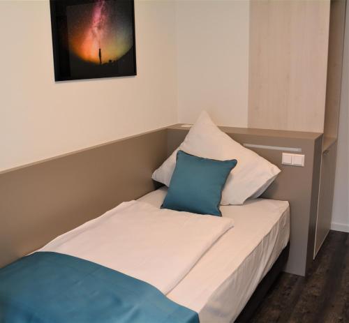 斯图加特Hotel BaWü的一张带两个枕头的床和一张墙上的照片