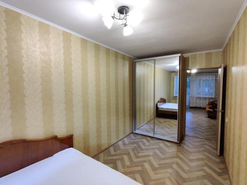 敖德萨Filatov apartment的一间卧室配有一张床,另一间卧室配有镜子