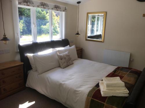 法纳姆Woodland Cabin With private Wood-Fired Hot-Tub的一间卧室配有带白色床单和枕头的床。