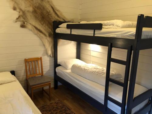 哈山Sørlia hytte的带两张双层床和椅子的房间