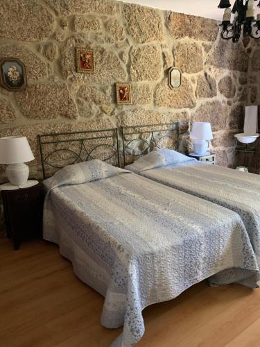 瓦勒福尔莫索金塔福尔摩沙旅馆的一间卧室设有一张床和石墙